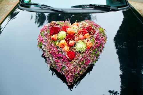 Der Blumenschmuck für das Fahrzeug muss nicht unbedingt weiß oder rosa sein, wie dieses Heideherz in Pink und Violett beweist.